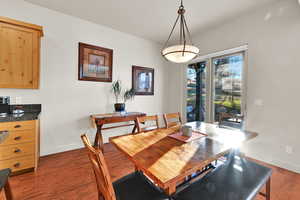 Dining space featuring dark wood-type flooring and baseboards