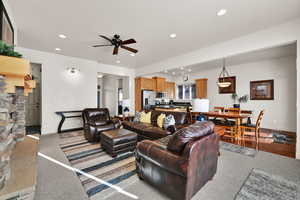 Living area with recessed lighting, ceiling fan, and light carpet