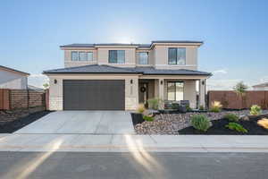 View of front of property featuring stucco and stone exterior, concrete driveway and attached garage.