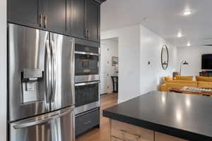 Kitchen featuring double ovens, open floor plan, luxury vinyl plank flooring.