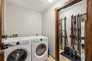 Clothes washing area with baseboards, laundry area, independent washer and dryer, and tile patterned floors