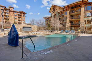 Community pool with fence and a patio