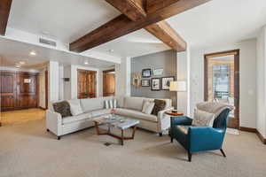 Living room with recessed lighting, visible vents, light carpet, beamed ceiling, and baseboards