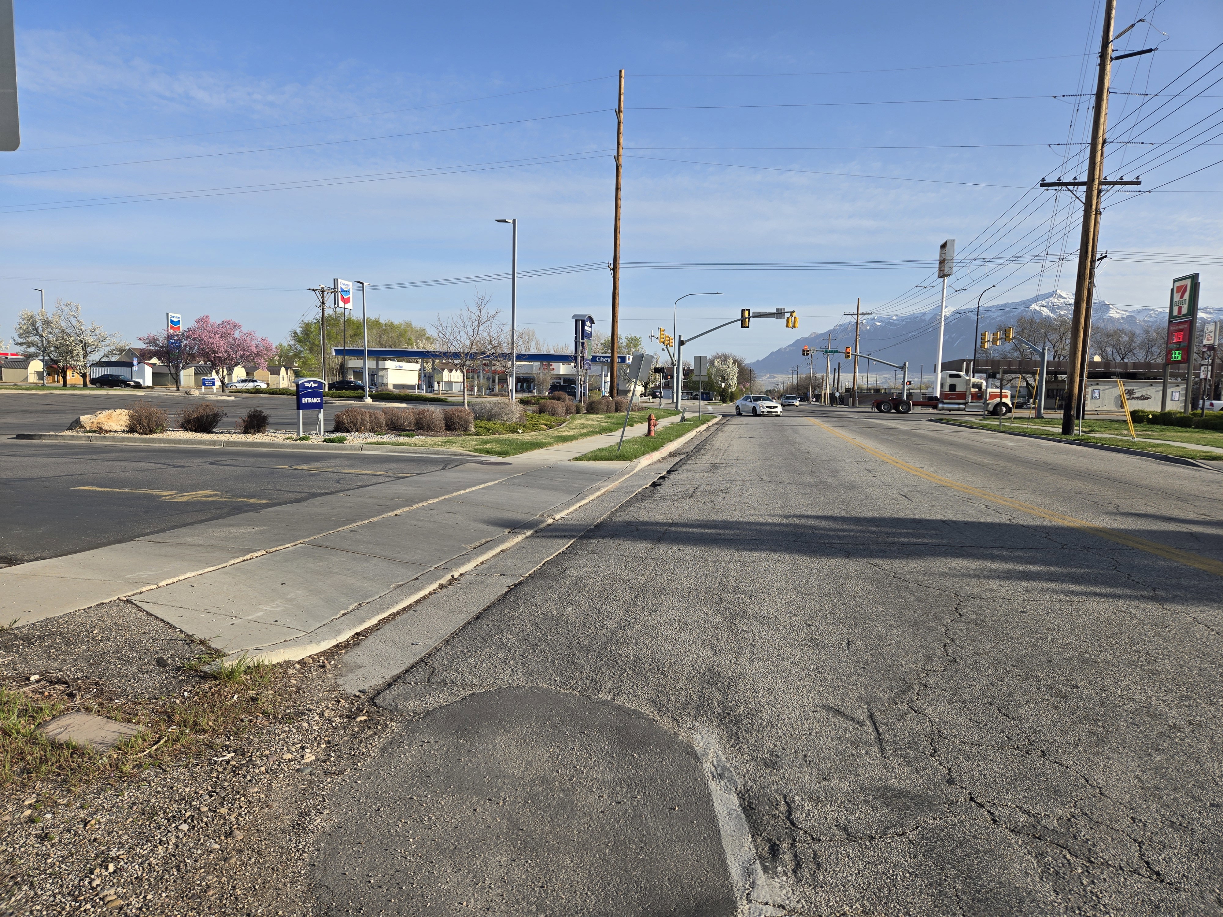 View of road featuring sidewalks, curbs, traffic lights, and street lighting