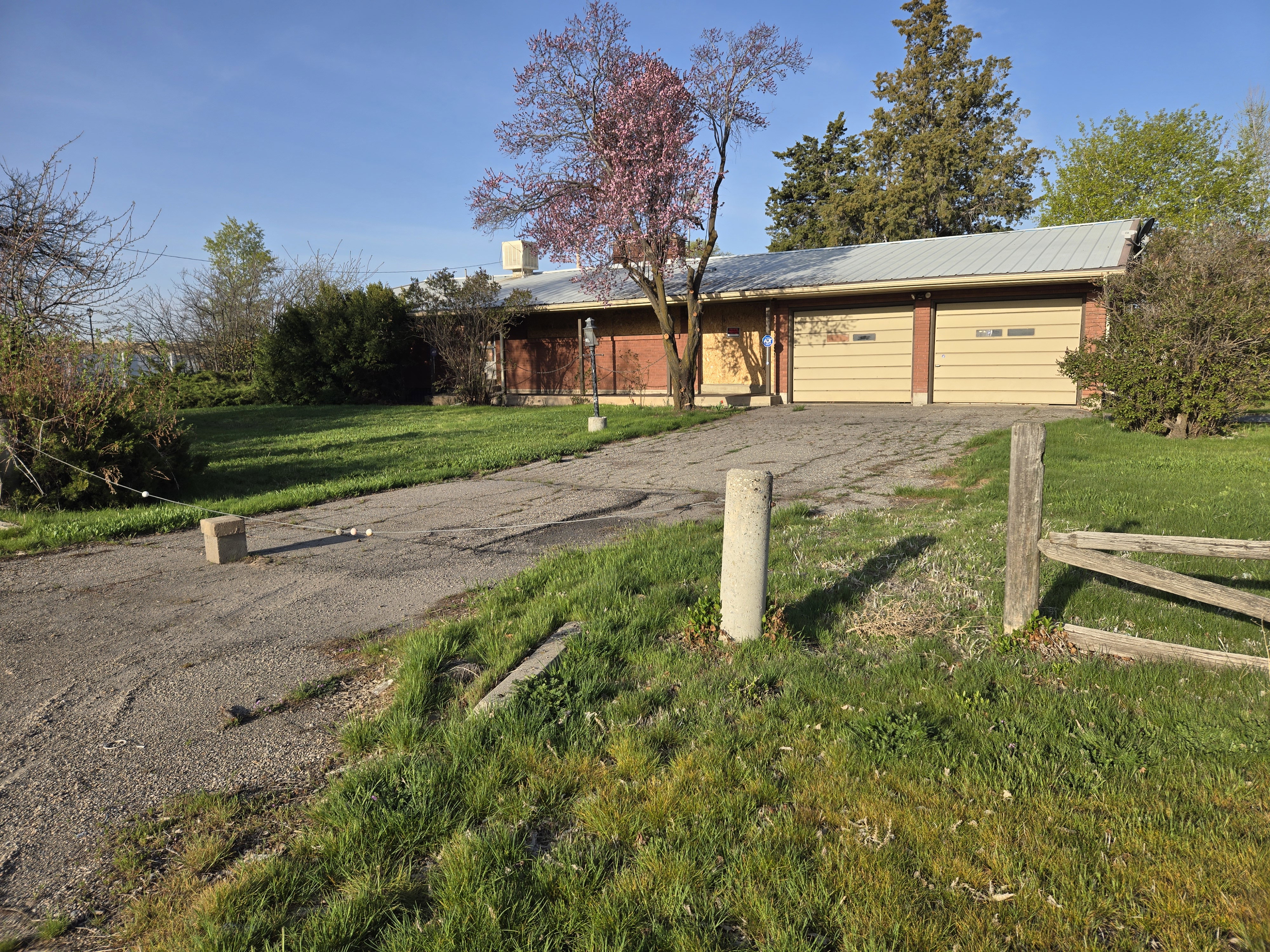 View of front facade featuring a garage, fence, driveway, and a front lawn