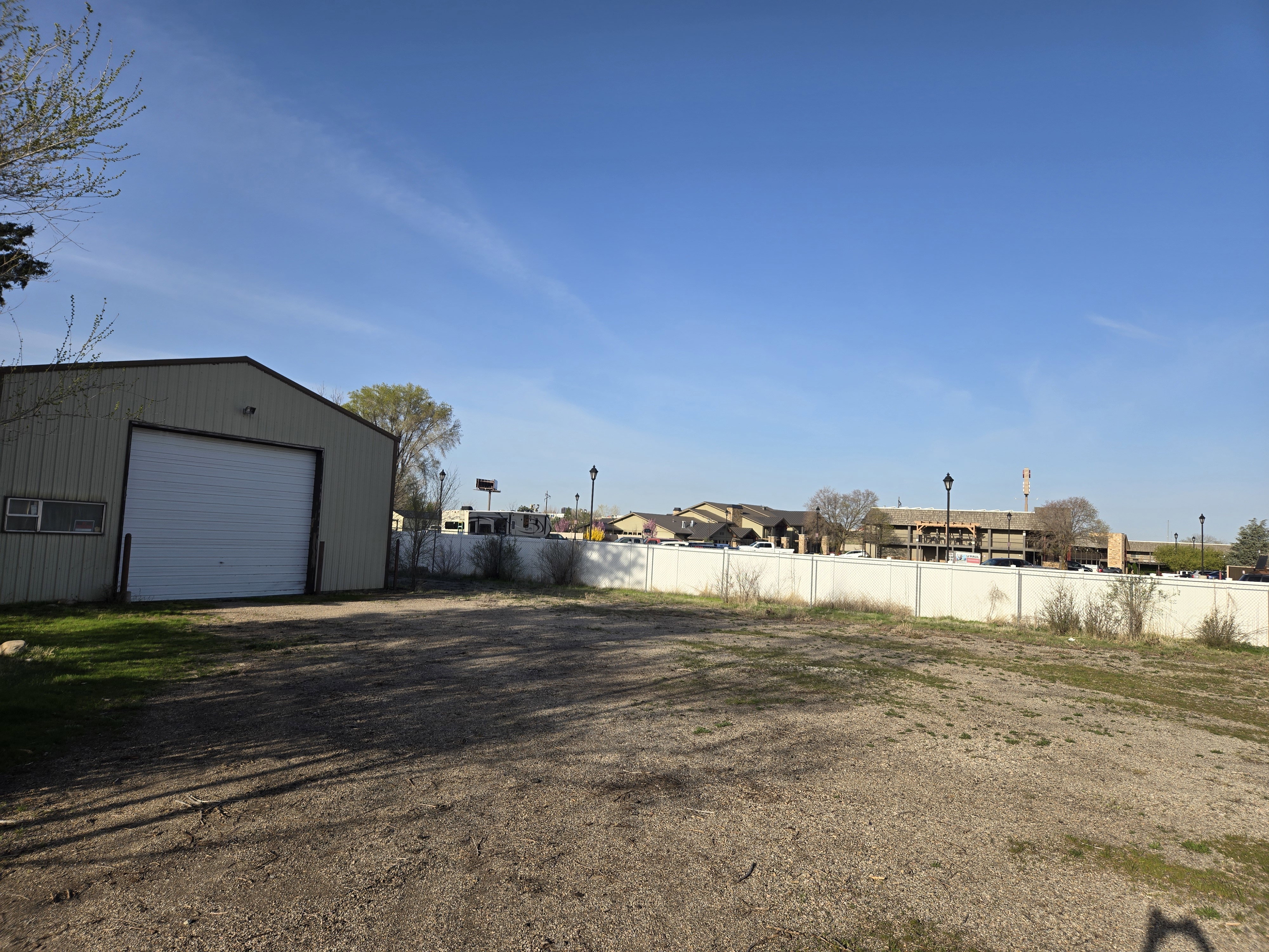 View of yard with a detached garage, fence, and an outdoor structure