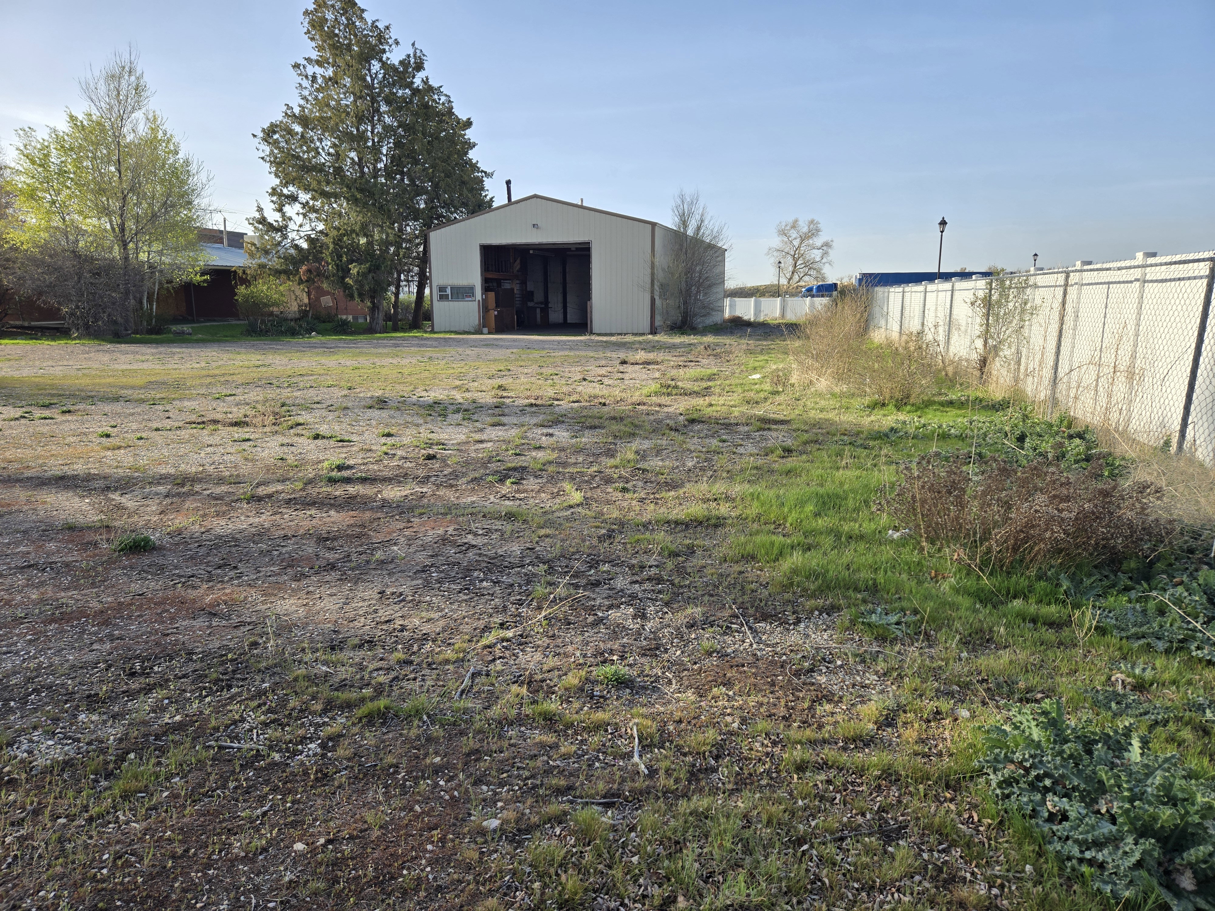 View of yard featuring fence and an outbuilding