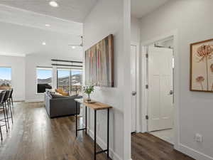 Hall with recessed lighting, a textured ceiling, baseboards, and wood finished floors