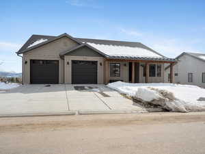 View of front facade featuring a garage, driveway, and board and batten siding