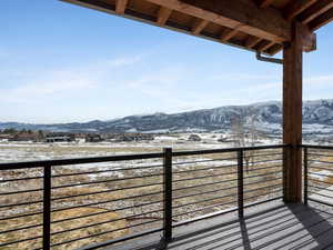 Snow covered back of property with a mountain view