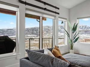 Bedroom featuring baseboards, multiple windows, a mountain view, and wood finished floors