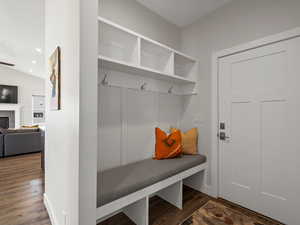 Mudroom with recessed lighting, dark wood-style flooring, and a tile fireplace