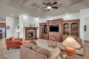 Living room with beam ceiling, recessed lighting, a premium fireplace, a ceiling fan, and coffered ceiling