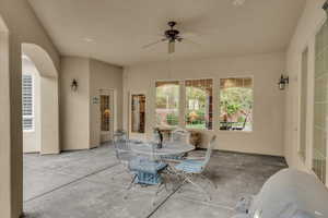 View of patio with ceiling fan and outdoor dining area