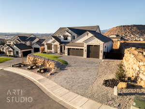 Modern farmhouse with a garage, a tile roof, decorative driveway, a mountain view, and board and batten siding