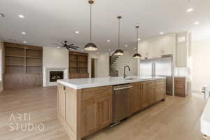 Kitchen featuring appliances with stainless steel finishes, recessed lighting, a fireplace, and a sink