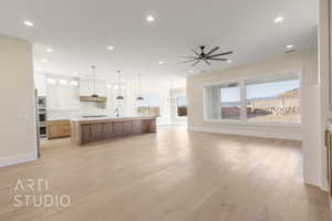 Unfurnished living room featuring light wood-style floors, visible vents, a sink, and recessed lighting