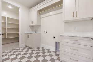 Laundry area with hookup for a washing machine, hookup for an electric dryer, a sink, cabinet space, and light floors