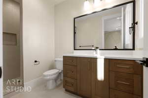 Bathroom featuring vanity, tile patterned flooring, walk in shower, and toilet