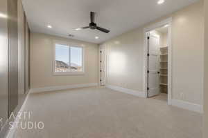 Unfurnished bedroom with recessed lighting, baseboards, a walk in closet, and light colored carpet