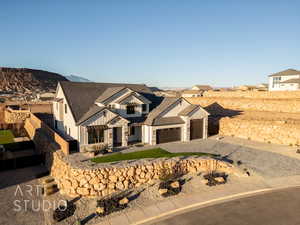 View of front facade with decorative driveway, board and batten siding, fence, a garage, and stone siding