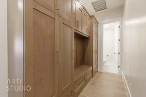 Mudroom featuring light wood-style floors, visible vents, and baseboards