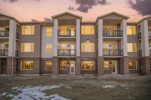 Back of property at dusk featuring brick siding