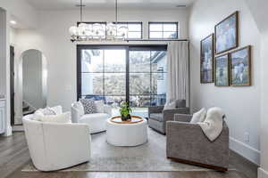 Living area featuring stairs, arched walkways, visible vents, and wood finished floors