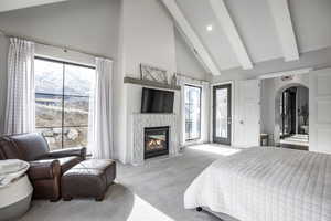 Bedroom featuring arched walkways, beam ceiling, light carpet, high vaulted ceiling, and access to outside