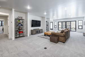 Carpeted living area featuring recessed lighting and baseboards