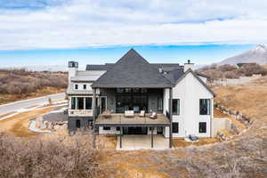 Back of property featuring a patio, a chimney, metal roof, a standing seam roof, and a mountain view