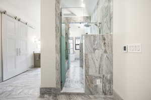 Full bathroom with a marble finish shower