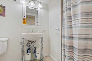 Bathroom with a sink, toilet, and baseboards