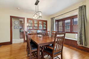 Dining room with a chandelier, light wood-style flooring, and baseboards