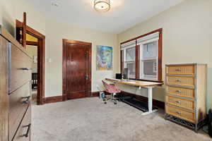 Carpeted home office featuring baseboards