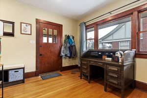 Office area with visible vents, light wood-style flooring, and baseboards