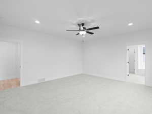 Unfurnished room with light carpet, visible vents, recessed lighting, baseboards, and a ceiling fan