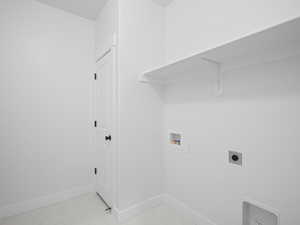 Washroom featuring baseboards, washer hookup, electric dryer hookup, laundry area, and light tile patterned floors