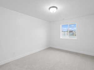 Empty room with visible vents, light carpet, and baseboards