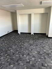 Unfurnished bedroom featuring carpet floors, visible vents, a textured ceiling, and baseboards