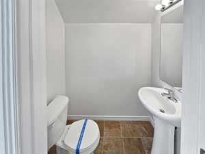 Bathroom with a sink, toilet, and baseboards