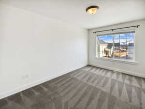 Spare room featuring carpet and baseboards