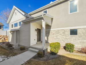 Property entrance featuring board and batten siding and stone siding