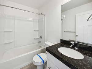 Full bathroom with toilet, shower / bathing tub combination, and vanity