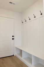 Mudroom with visible vents and light wood finished floors