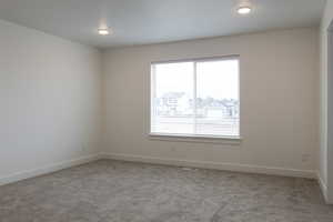 Carpeted spare room with baseboards and visible vents
