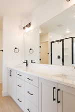 Full bath featuring wood finished floors, a sink, and double vanity