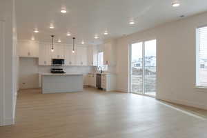Kitchen featuring plenty of natural light, baseboards, decorative backsplash, and appliances with stainless steel finishes