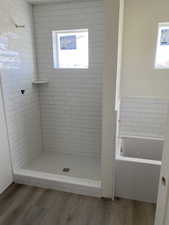 Full bathroom featuring a stall shower, a garden tub, and wood finished floors