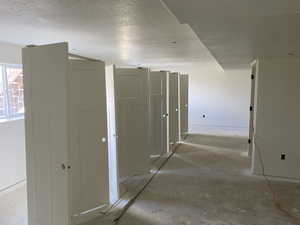 Hallway featuring baseboards and a textured ceiling